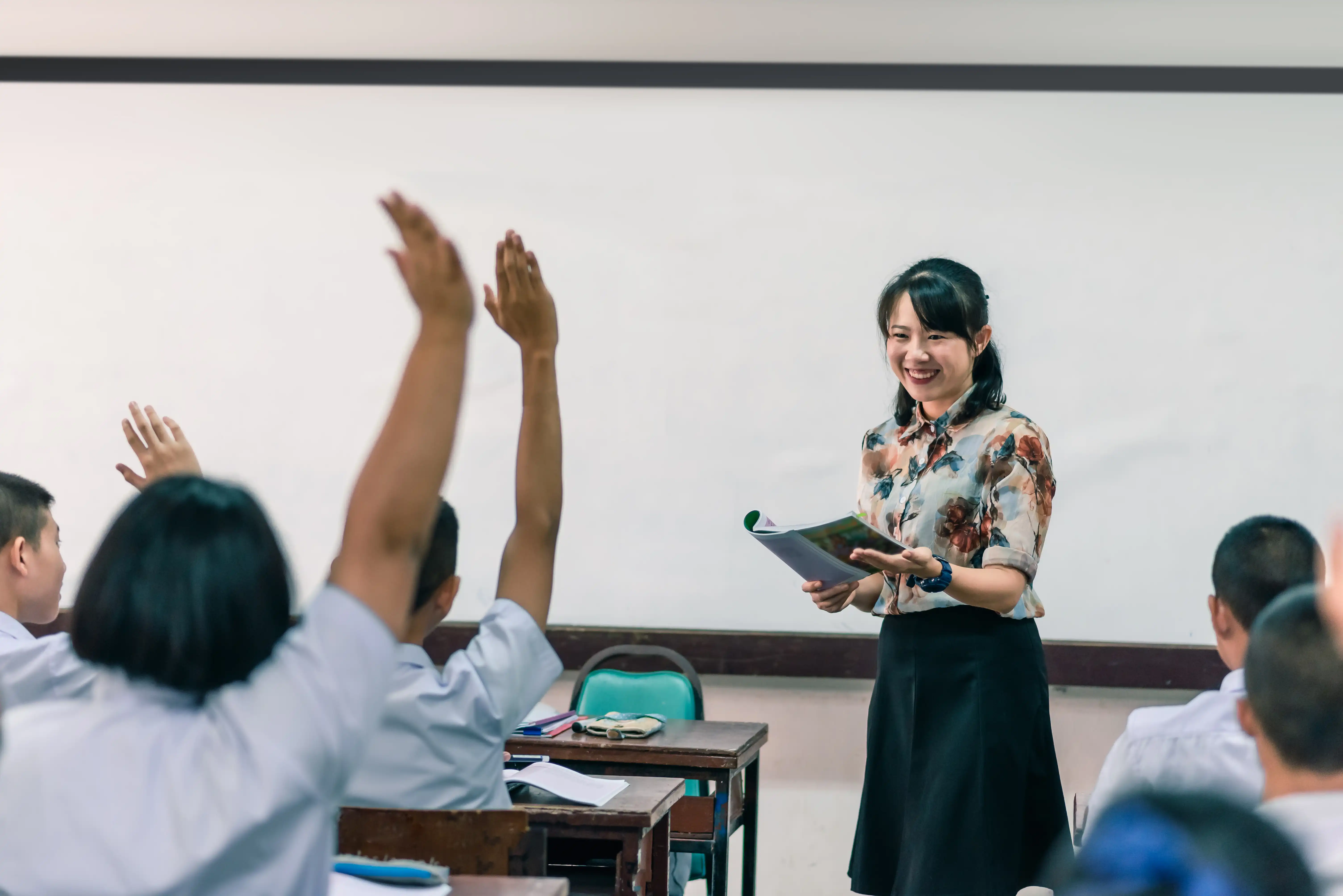 Students raising their hands in a classroom